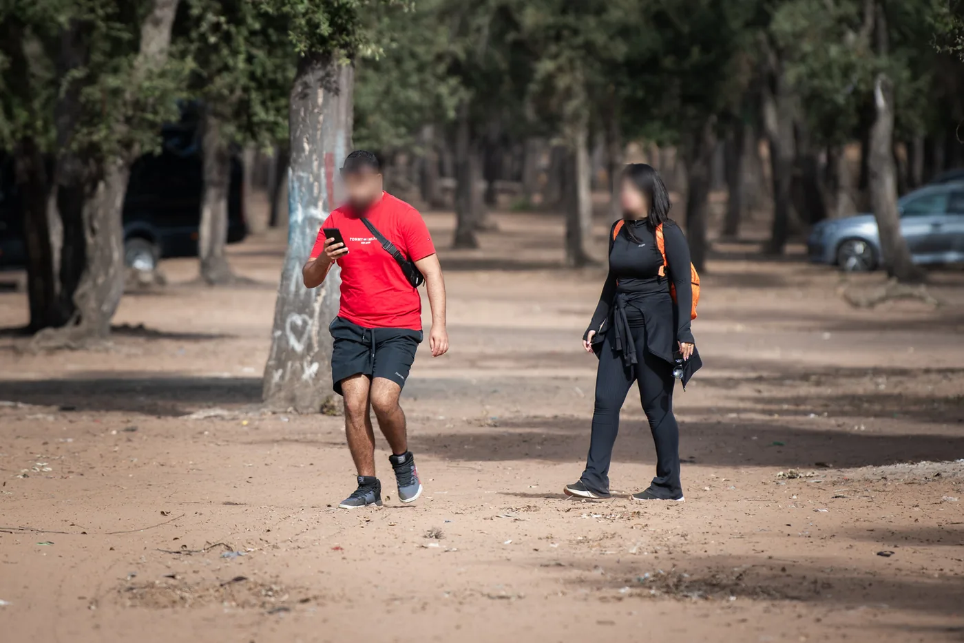 Deux participants du Maamora Challenge traversant la forêt, téléphone en main.